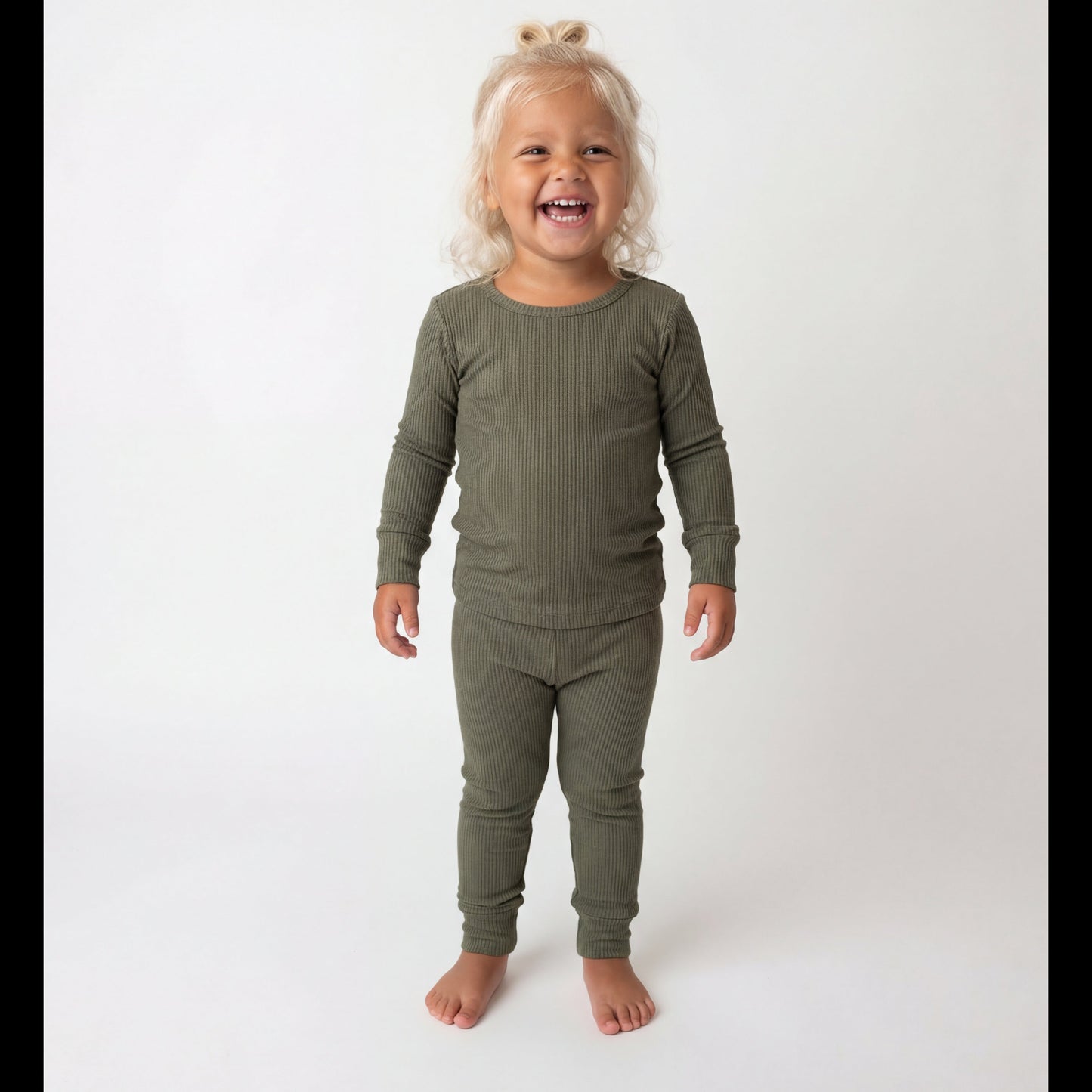 Child wearing a green long-sleeve shirt and pants on a white background