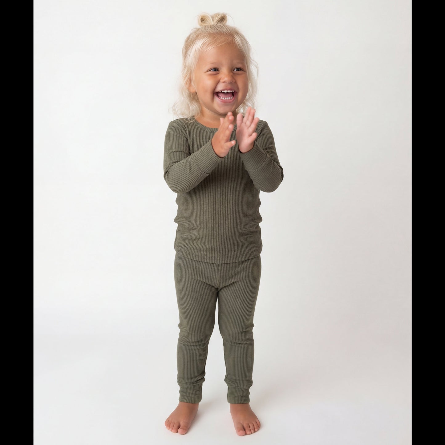 Child wearing a green outfit on a white background