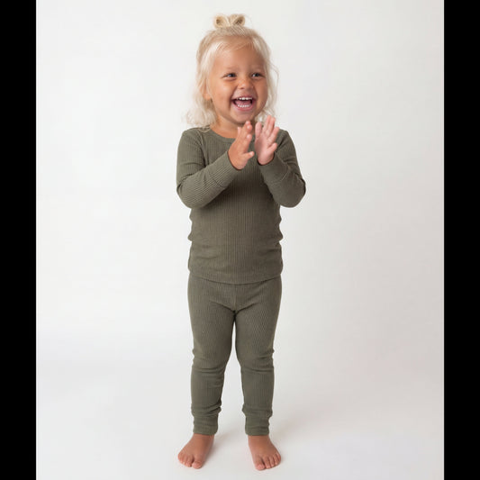 Child wearing a green outfit on a white background
